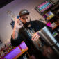 Chance Fisher, Head of People at Beds and Bars, pours a shot in a bar