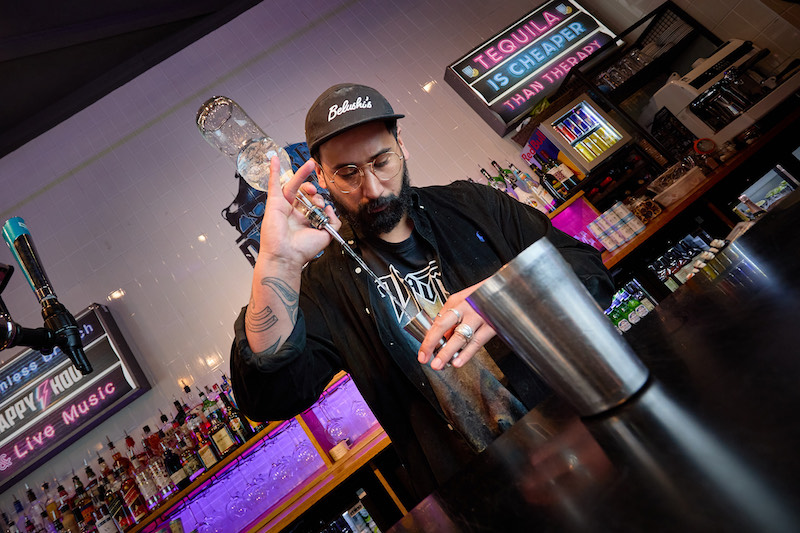 Chance Fisher, Head of People at Beds and Bars, pours a shot in a bar